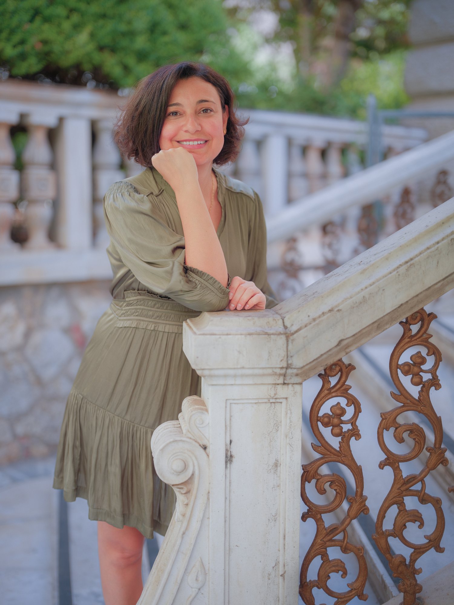 Elina Lagoudaki leaning on a marble staircase