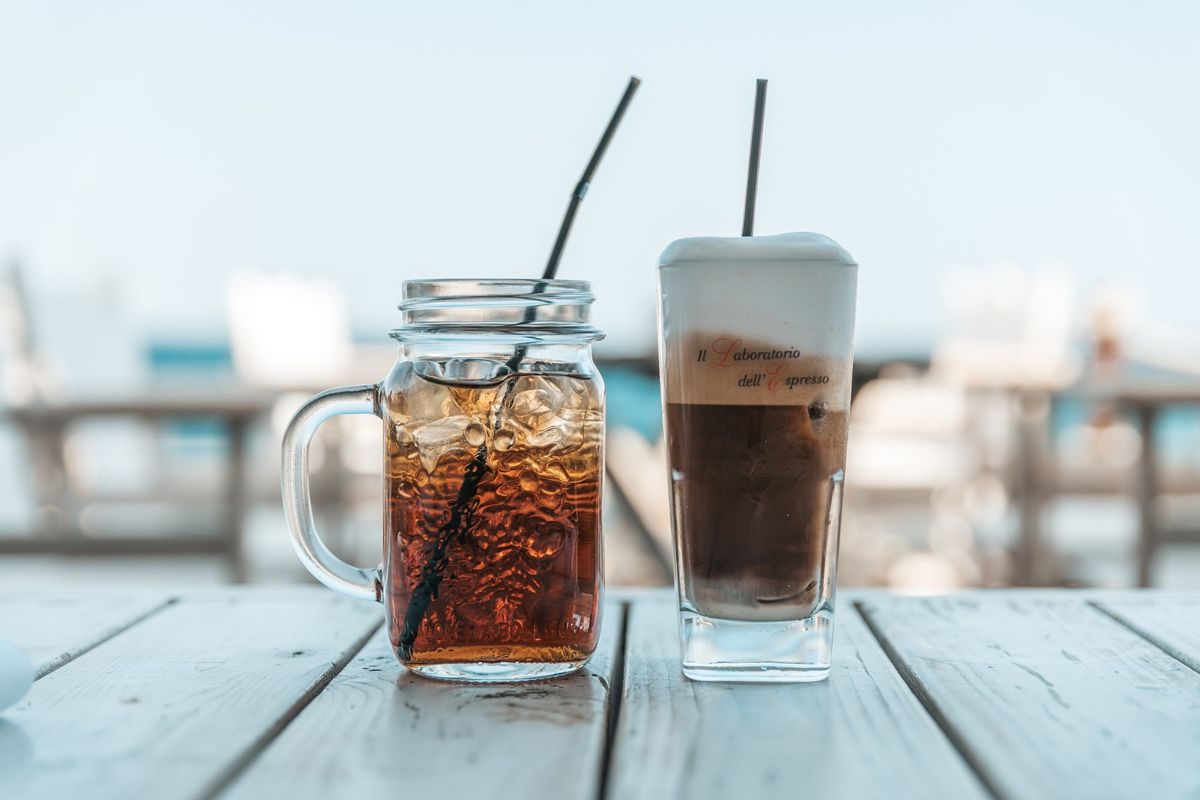 Iced Greek frappé coffees on a seaside café table
